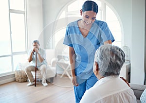 How are you doing today. an attractive young female nurse doing her rounds in the old age home.