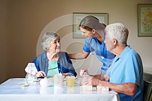 Hows everything. two residents and a nurse at a retirement home.