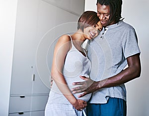 Hows my baby doing today. a young man touching his pregnant wifes belly.