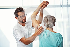 Hows that rotator cuff. a senior woman working through her recovery with a male physiotherapist.