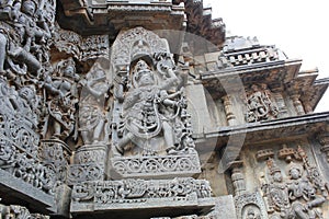 Hoysaleswara Temple outer wall carved with sculpture of Garuda, the humanoid bird
