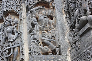 Hoysaleswara Temple wall carved with sculpture of Darpana Sundari beautiful lady with mirror