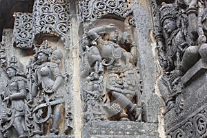 Hoysaleswara Temple wall carved with sculpture of Darpana Sundari beautiful lady with mirror