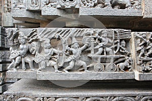 Hoysaleswara Temple wall carved with sculpture of warriors and ancient battle scene