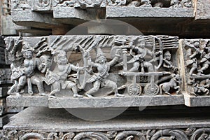 Hoysaleswara Temple wall carved with sculpture of warriors and ancient battle scene