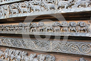 Hoysaleswara Temple wall carved with sculptures of mystical animals and tug of war