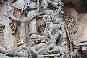Hoysaleswara Temple wall carving of demon drinking blood from the head of an asura photo