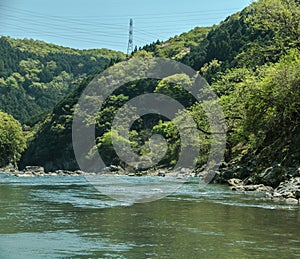 Hozugawa River by the rocky green hills.