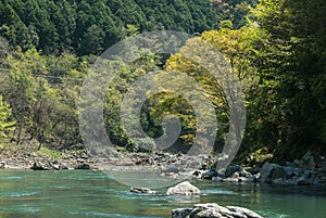 Hozugawa River by the rocky green hills.