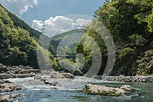 Hozugawa River by the rocky green hills.