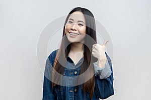 Hppy smiling woman standing showing thumb up, like gesture, recommend service.