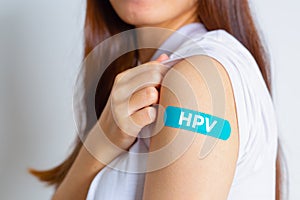 HPV Human Papillomavirus Teenager woman showing off an blue bandage after receiving the HPV vaccine.viruses Some strains infect photo