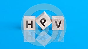 HPV - Human papillomavirus, word written on blocks. Humani Papilloma Virus inscription on blue background. Medical viruses concept