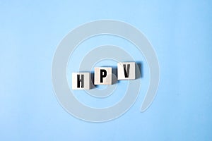 HPV word written on wood block. HPV text on blue for your desing, Top view concept