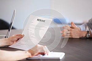 Hr holding reading resume at job interview, close up view