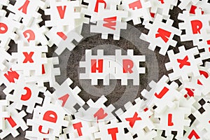 HR, Human Resources concept, white puzzle jigsaw with alphabet building the word HR at the center, job and career recruitment