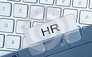 HR - Human Resources - folder with text on computer keyboard