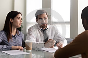 HR managers seated at desk in office interviewing African applicant