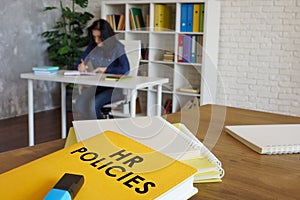 HR policies guide book on desk near employee.