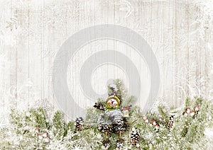 Ð¡hristmas background. Snow firtree with cones and snowman, on wooden white board. Greeting holiday card