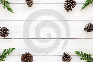 Hristmas frame made of fir leaves and pine cones decoration rustic elements on white wooden