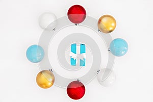 Hristmas pastel blue gift boxes inside round frame made of Colorful balls on white background.