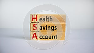 HSA symbol. Wooden cubes and blocks with words `HSA - Health Savings Account`. Beautiful white background. Business and HSA