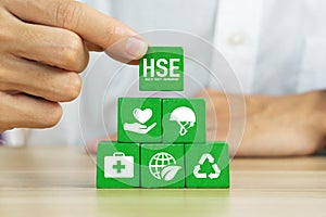 HSE - health safety environment concept.Hand holding wooden cube block with HSE icon.Work safety Regulation rules business.Safe