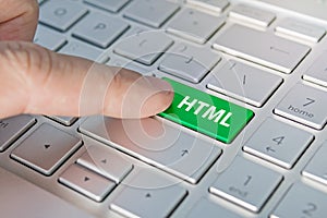 HTML computer language. writing on button modern of gray laptop. Finger presses the button. Programmer for work.