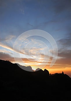 Huangshan Mountain in Anhui Province, China. Sunset over Huangshan with the mountain ridge and the sun nearly set