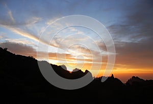 Huangshan Mountain in Anhui Province, China. Sunset over Huangshan with the mountain ridge and the sun nearly set