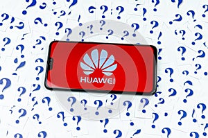 HUAWEI logo on the HUAWEI smartphone and a lot of paper question marks around.