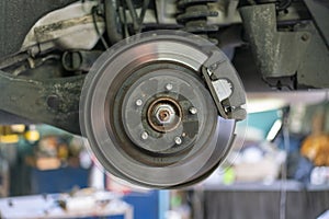The hub of a wheel in a car service. Suspended car with no wheels. Suspension of car in service room.The car lift up by