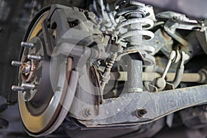 The hub of a wheel in a car service. Suspended car with no wheels. Suspension of car in service room. Close up