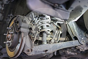 The hub of a wheel in a car service. Suspended car with no wheels. Suspension of car in service room. Close up