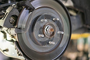 The hub of a wheel in a car service. Suspended car with no wheels. Suspension of car in service room. Close up. toned