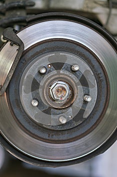 The hub of a wheel in a car service. Suspended car with no wheels. Suspension of car in service room. Close up. toned. vertical