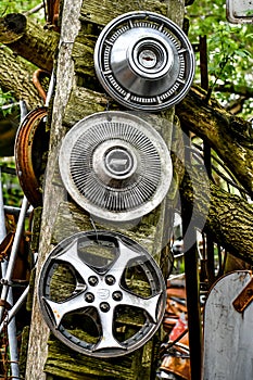 Hubcap Collection Hanging on Old Wood