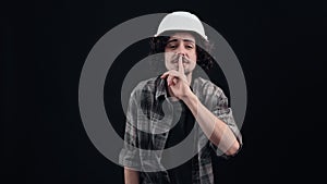 Huch, don't tell anyone. The secret engineer, wearing a white helmet, puts his finger to his mouth as a sign of secrecy