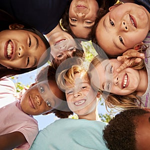 A huddle of school kids looking down at camera, close up photo