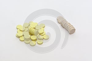 Huddle of yellow tablets with parting lines and neat stack of be