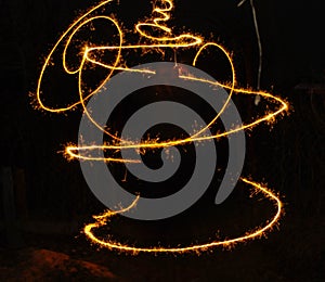 Hudozhniki juggling with two flaming poi's on fire. Prolonged exposure causes painting with light. Background.