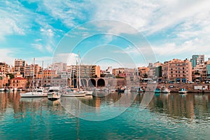 Hue shifted photo of heraklion city old port panoramic view sea sky boats floating and building vintage look