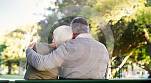 Hug, bench and a senior couple outdoor in a park with love, care and support in marriage. Back of elderly man and woman