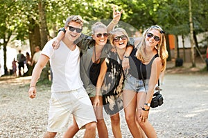 Hug, celebration and friends at a park for festival, concert or happy social gathering. Face, fun and people in a forest