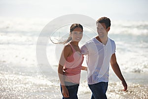 Hug, love and couple at a beach walking, calm and bonding on ocean adventure together. Travel, sunset and people at sea