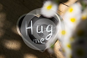 Hug me hand drawing phrase on a heart, Share a Hug Day concept