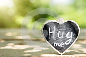 Hug me hand drawing phrase on a heart, Share a Hug Day concept