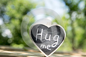 Hug me hand drawing phrase on a heart, Sharing a Hug concept