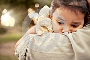 Hug, park and sad girl with parent for comfort, care and support while outdoors in nature. Family, love and mom